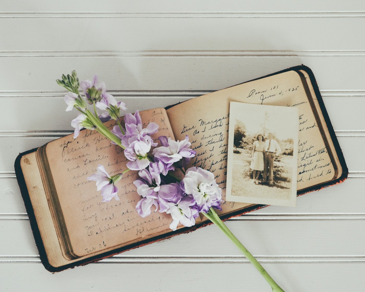 Carnet manuscrit ancien accompagné d’une photographie et de fleurs